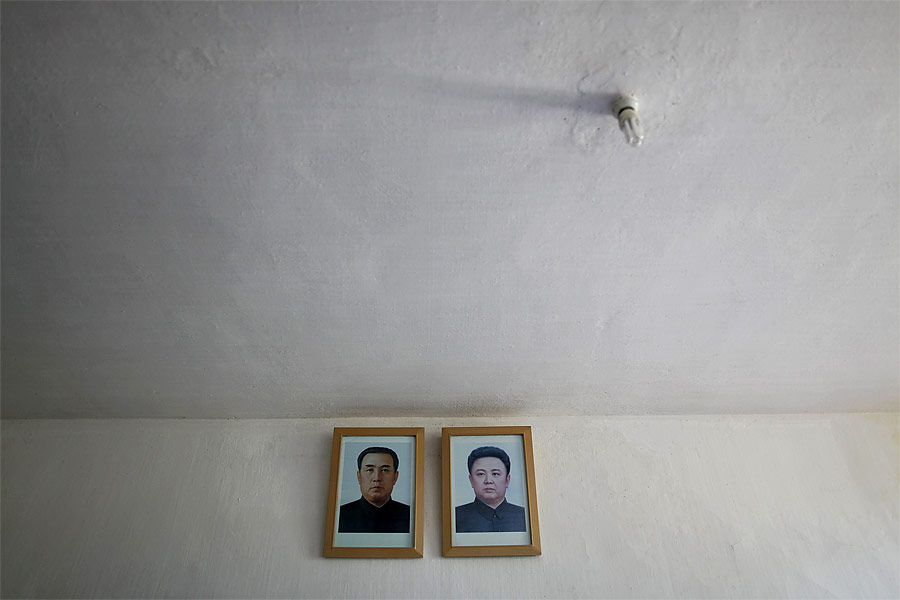 Портреты северокорейских лидеров Ким Ир Сена и Ким Чен Ира на стене госпиталя в Хэджу. © Damir Sagolj/Reuters