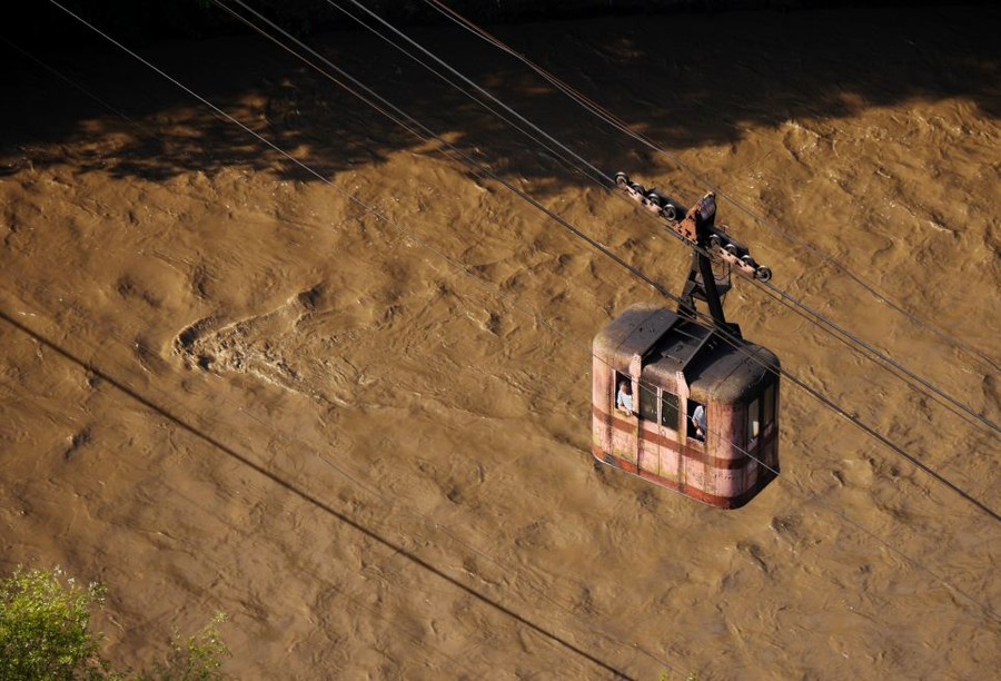 View: A cabin from Tramway 25 travels over the strong currents of the Kvirila River. This would have been a daily spectacle for miners during the Soviet era