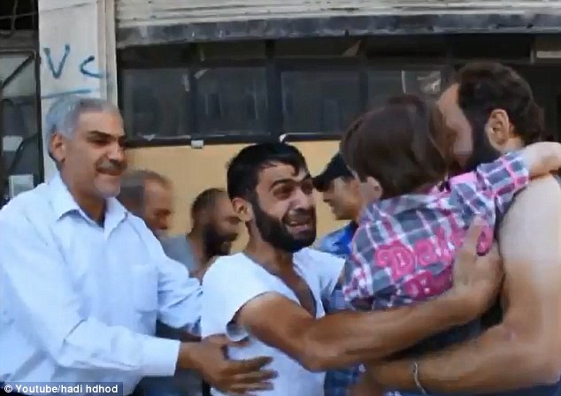 Parent's worst nightmare: The father (center) presumably thought his young son had been killed in last week's attack 