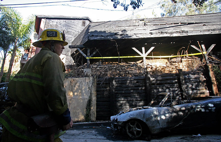 Сотрудник противопожарной службы Лос-Анджелеса у сгоревшего автомобиля возле дома Джима Моррисона. © Ringo H.W. Chiu/AP Photo