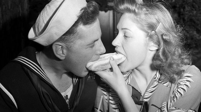 Идиллия на Кони-Айленде: моряк и его девушка вместе едят один хот-дог