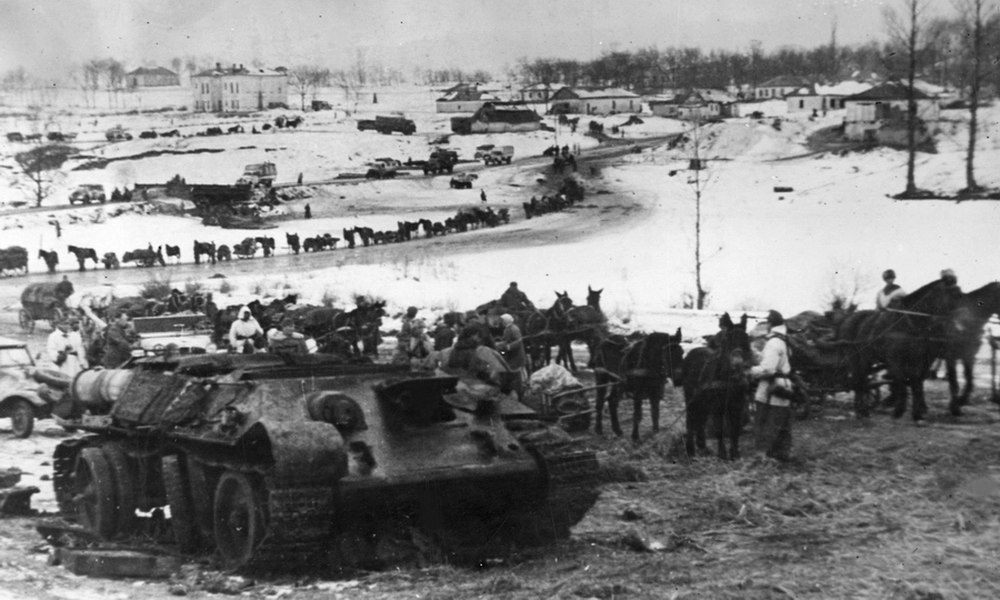 Немецкие войска проходят мимо уничтоженного советского танка Т-34, январь 1944 года