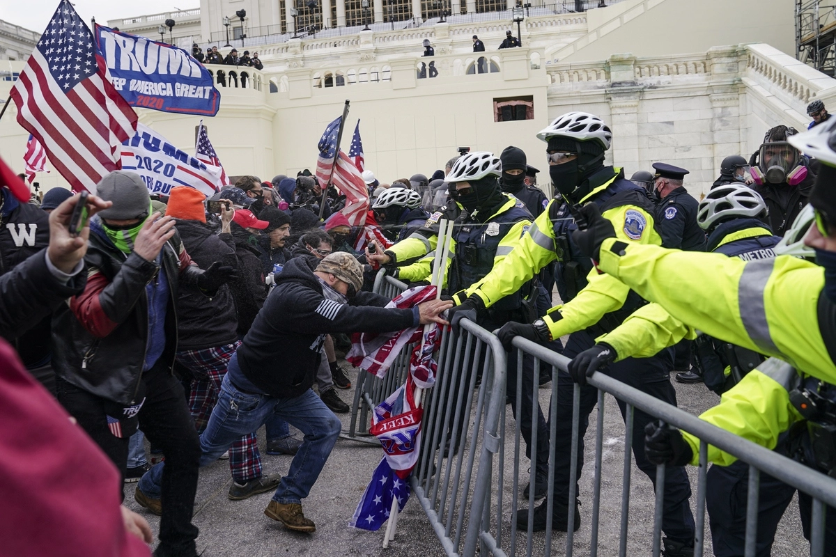 Сторонники Дональда Трампа пытаются прорваться сквозь оцепление у здания Конгресса США в Вашингтоне.