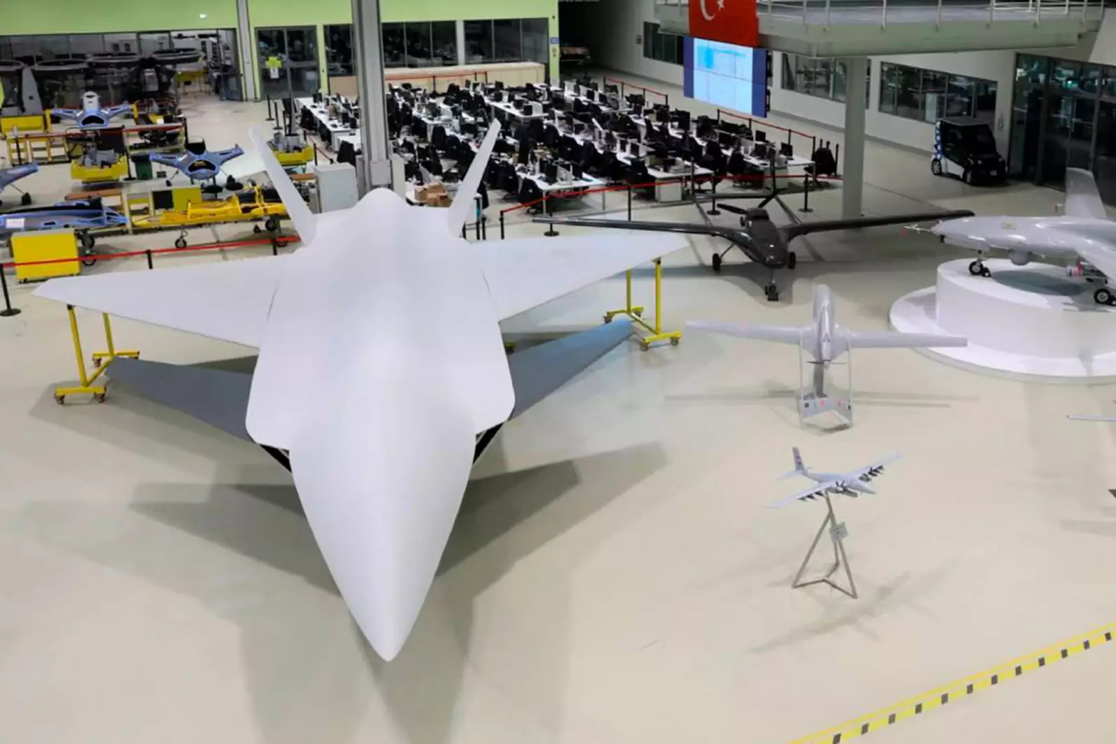 Полноразмерный макет БПЛА «Kizilelma» слева.
