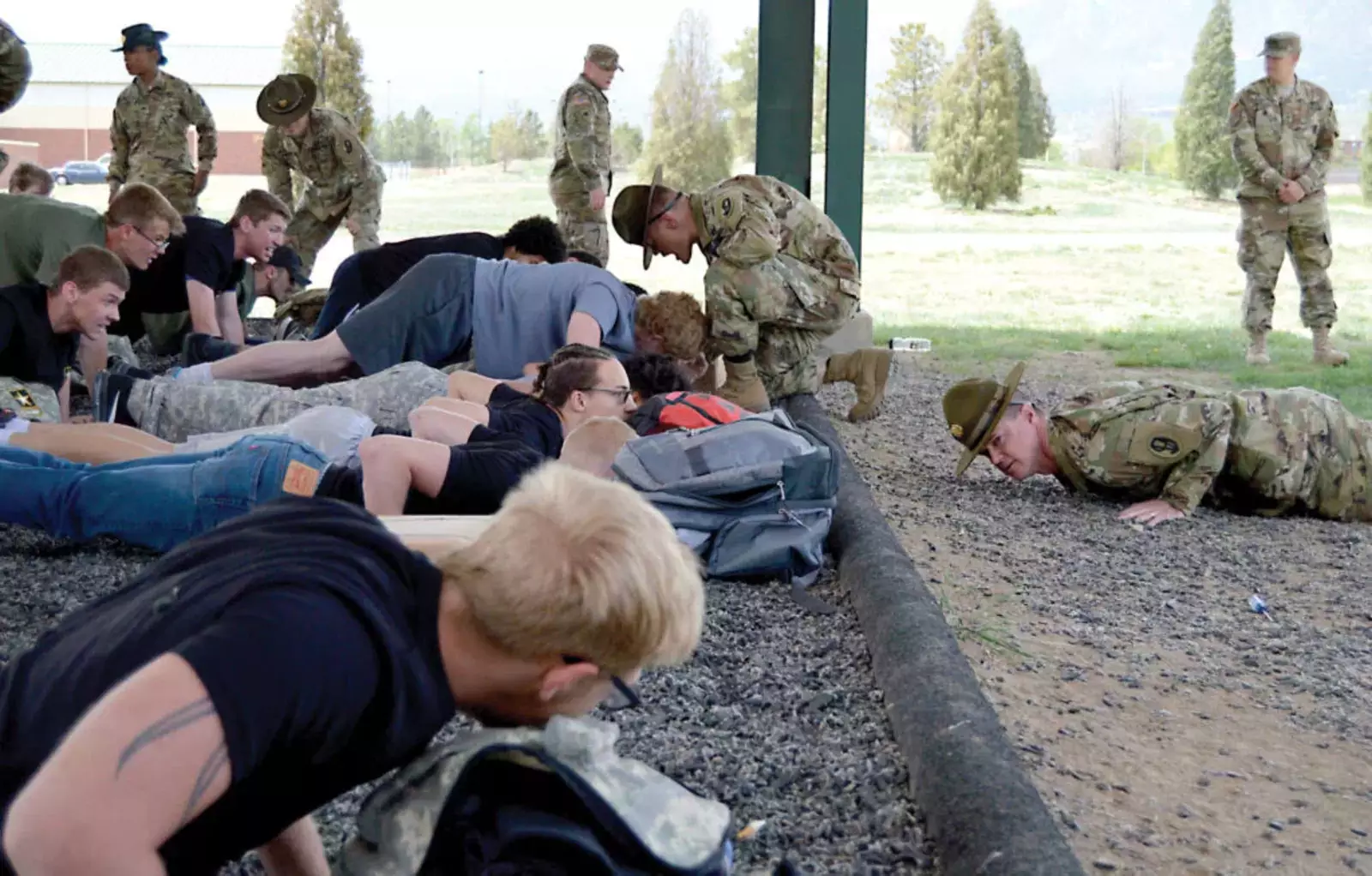 Сержанты резерва армии 415-го пехотного полка инструктируют будущих солдат о надлежащей технике отжимания во время мероприятия Future Soldier на Першинг-Филд 12 мая 2018 года в Форт-Карсон, штат Колорадо